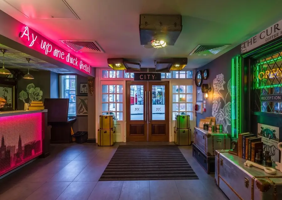 Nottingham City Centre Hotel by Sunday lobby with neon signs and vintage trunks